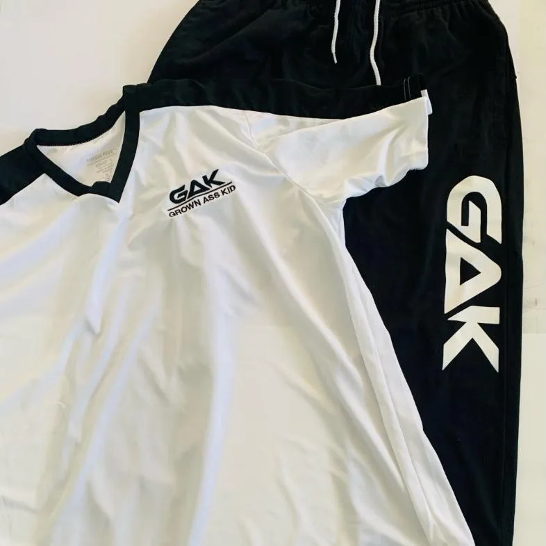 White GAK jersey and black GAK pants flat lay