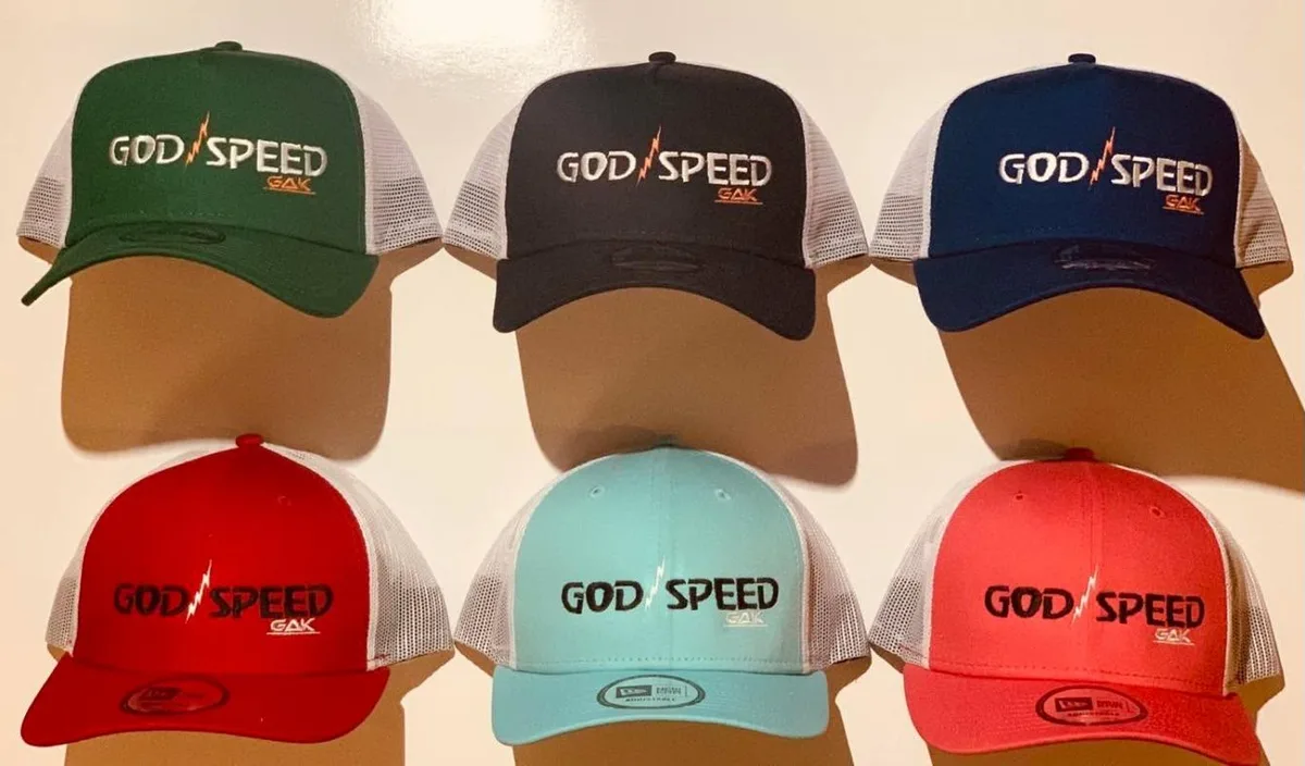 Six GOD SPEED GAK trucker caps in green, black, navy, red, teal and coral