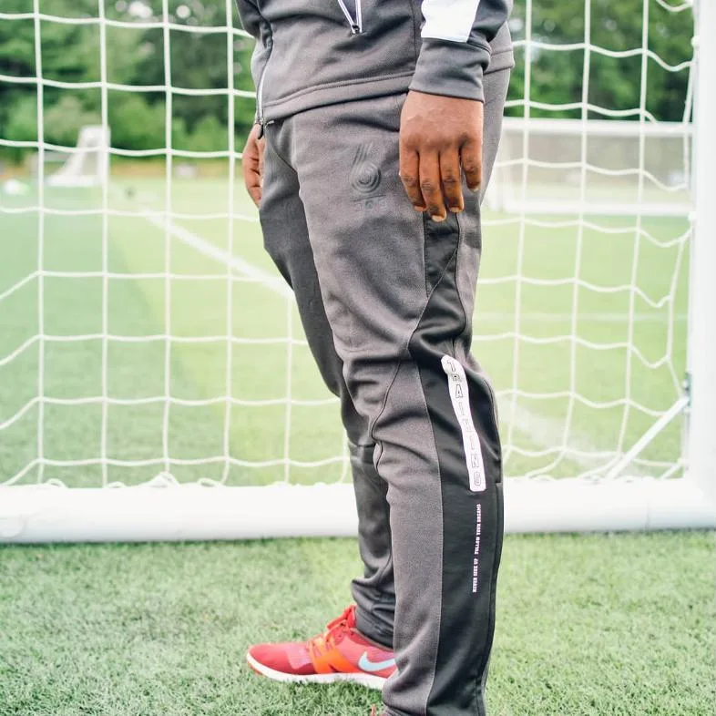 GAK training pants detail shot in front of a soccer goal